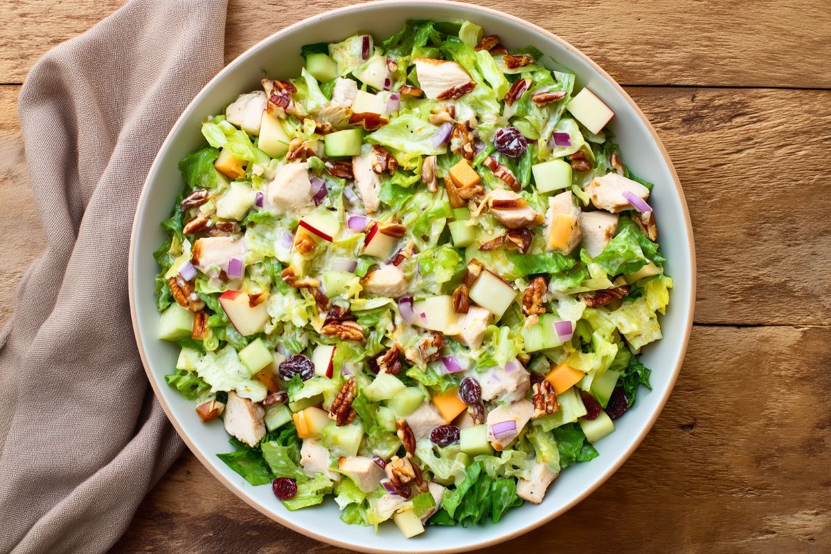 Maple Dijon chicken chopped salad with diced chicken, apples, pecans, dried cranberries, cheddar, red onion, lettuce, and creamy dressing.