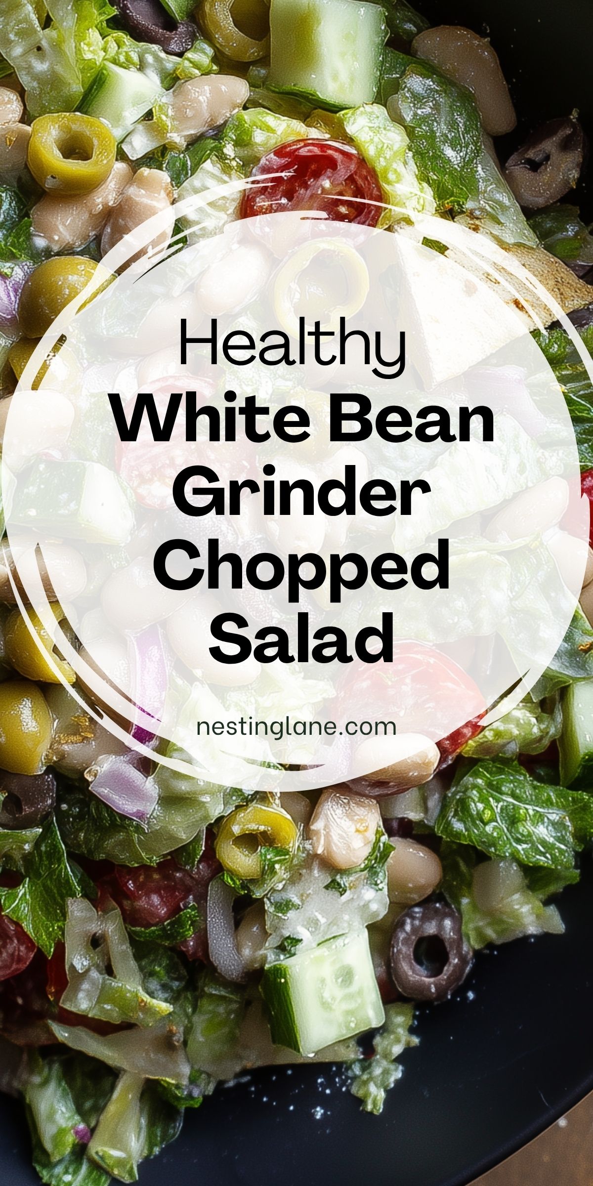 Healthy white bean grinder chopped salad with lettuce, cucumber, cherry tomatoes, green and black olives, red onion, and white beans. Text reads “Healthy White Bean Grinder Chopped Salad” and “nestinglane.com.”