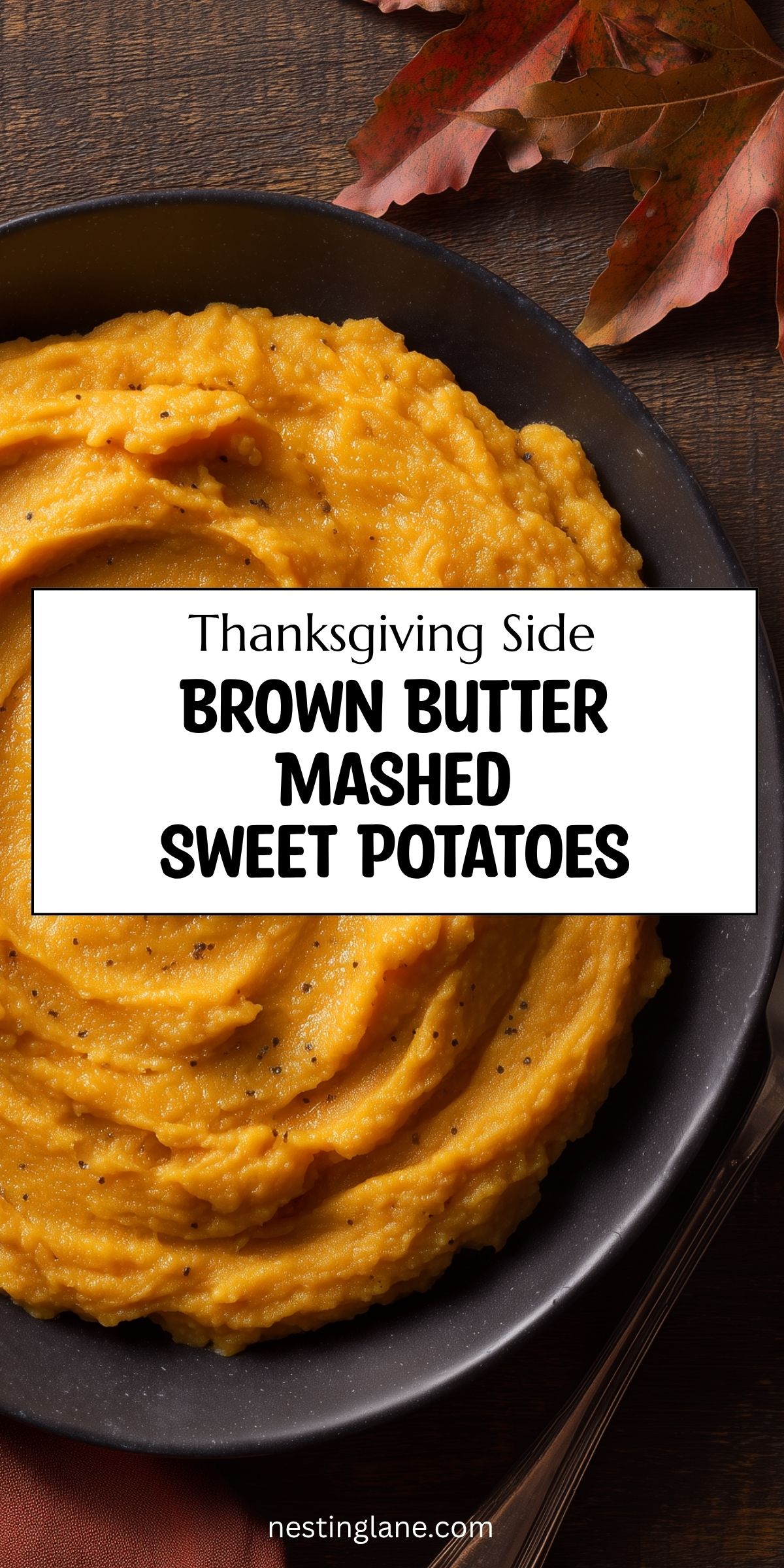 Brown butter mashed sweet potatoes in a black bowl on a dark rustic table with autumn leaves. Text reads: “Thanksgiving Side Brown Butter Mashed Sweet Potatoes” and “nestinglane.com.”