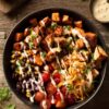 Overhead view of a chicken taco ranch sweet potato bowl with roasted sweet potatoes, chicken, black beans, corn, tomatoes, red onion, cheese, and ranch dressing.