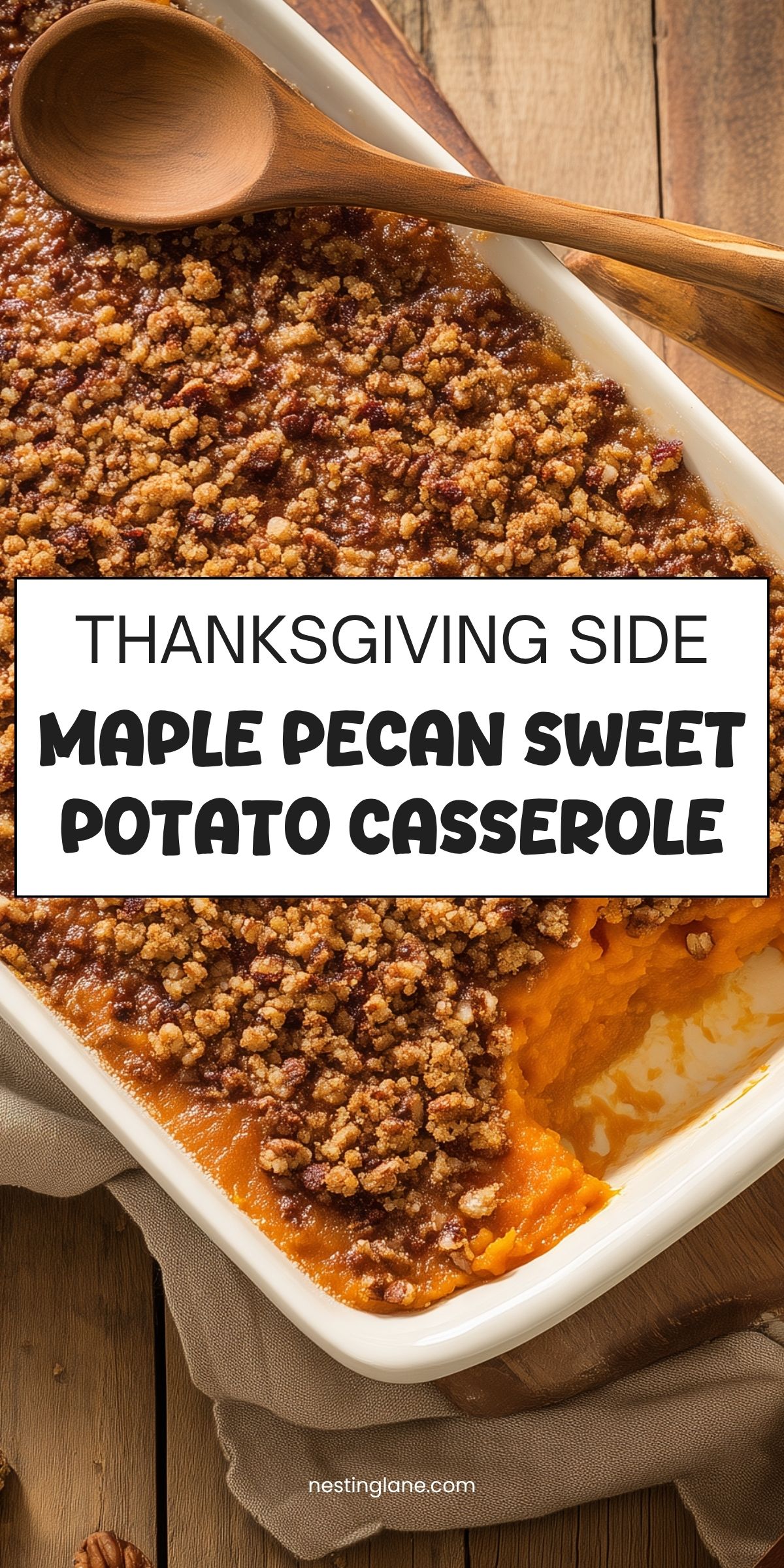 Maple pecan sweet potato casserole in a white baking dish with a brown sugar pecan crumble topping and a wooden spoon. Text reads: “THANKSGIVING SIDE MAPLE PECAN SWEET POTATO CASSEROLE” and “nestinglane.com.”