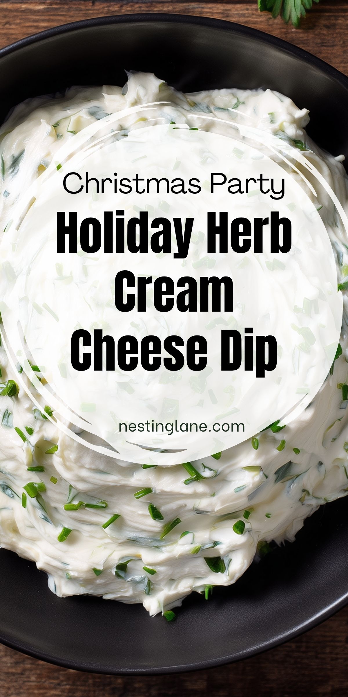 Creamy Holiday Herb Cream Cheese Dip with fresh chopped herbs in a black bowl on a rustic wooden table. Text reads "Christmas Party Holiday Herb Cream Cheese Dip" and "nestinglane.com."