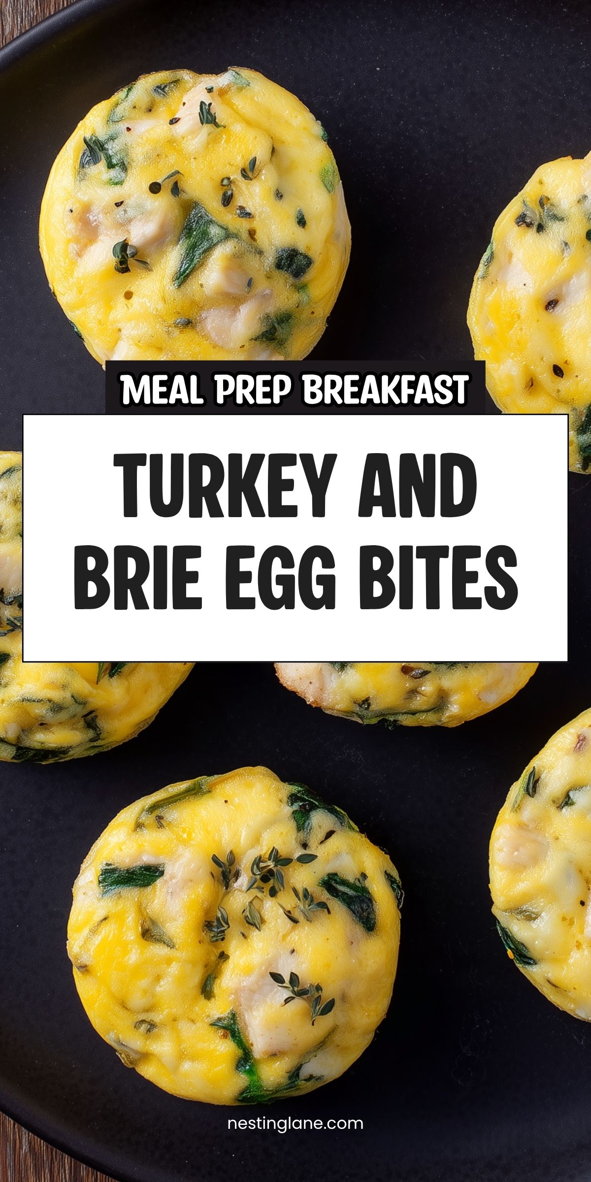 Turkey and Brie Egg Bites with spinach and herbs on a black plate. Text reads “Meal Prep Breakfast Turkey and Brie Egg Bites” and “nestinglane.com.”